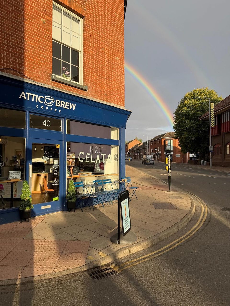 The Attic Brew blue storefront on Exchange Street under a rainbow